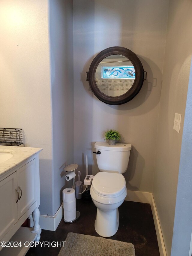 half bathroom with toilet, baseboards, and vanity