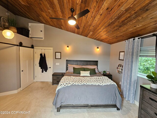 bedroom featuring light colored carpet, a barn door, vaulted ceiling, wooden ceiling, and baseboards