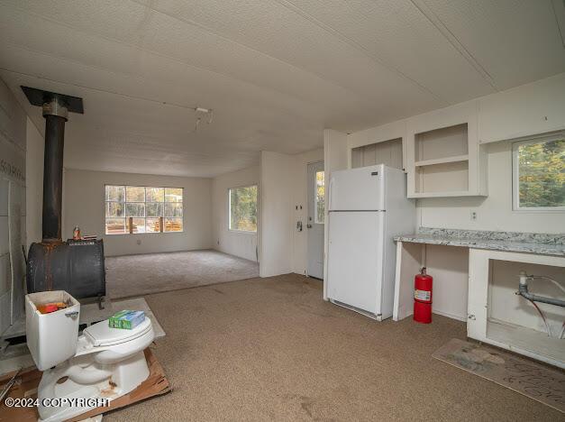 interior space with white fridge and a wood stove