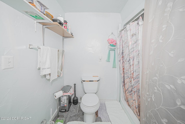 bathroom featuring walk in shower and toilet