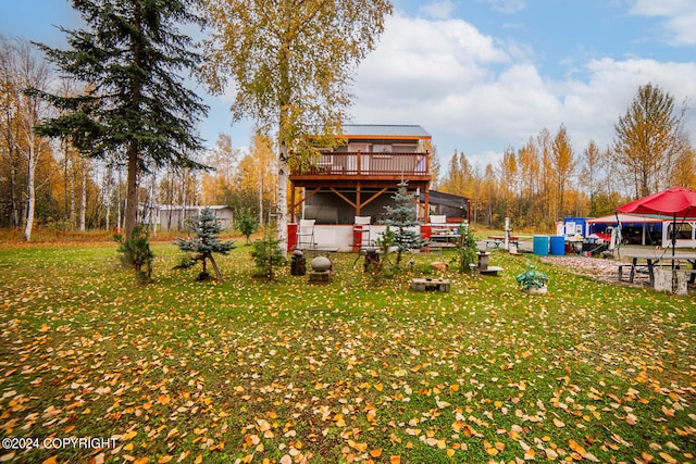 back of property featuring a wooden deck and a lawn