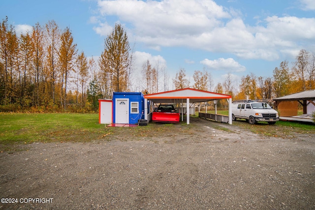 view of vehicle parking featuring a lawn and a carport