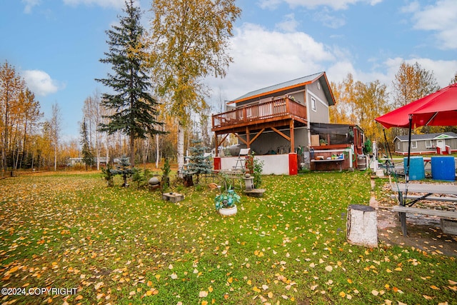 rear view of property with a wooden deck and a yard