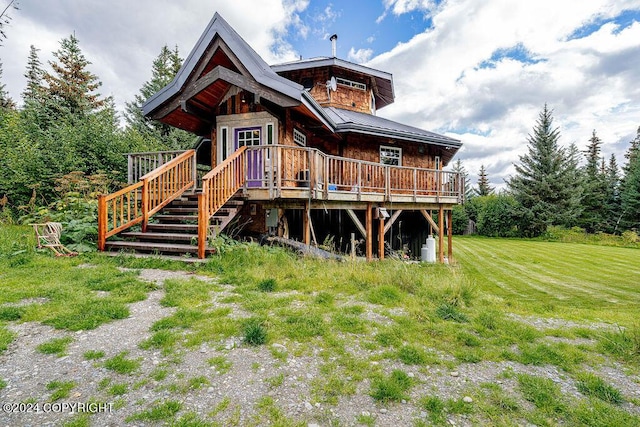 38126 Bobby Rufus Rd, Homer, AK 99603 - back of property with a wooden deck, metal roof, stairs, and a yard