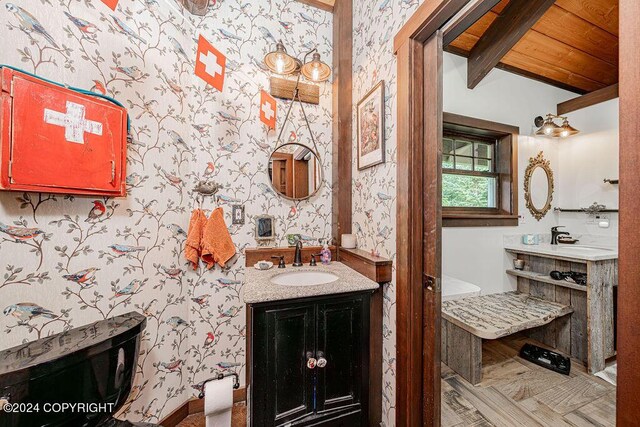 38126 Bobby Rufus Rd, Homer, AK 99603 - bathroom featuring wallpapered walls, vanity, wooden ceiling with exposed beams, and baseboards