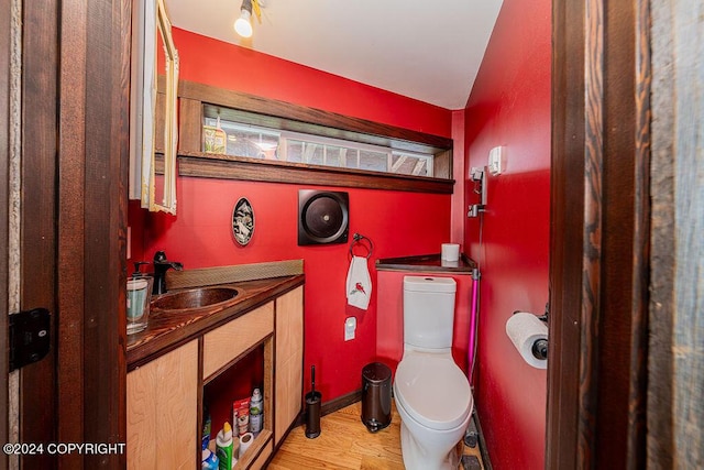 38126 Bobby Rufus Rd, Homer, AK 99603 - half bathroom featuring vanity, toilet, wood finished floors, and baseboards