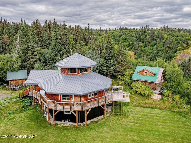 38126 Bobby Rufus Rd, Homer, AK 99603 - back of property with a forest view, a lawn, metal roof, and a deck