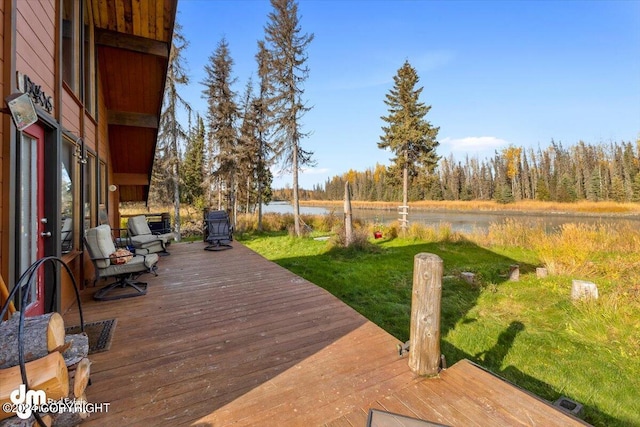 wooden deck with a yard and a water view