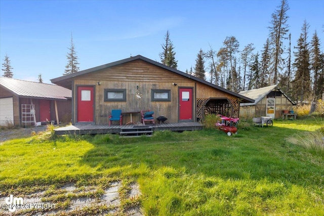 34464 Fishermans Rd, Soldotna, AK 99669 - view of front of home featuring an outbuilding, a wooden deck, a front lawn, and a detached garage
