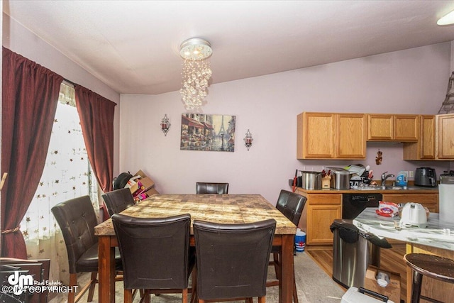 dining room featuring light carpet, vaulted ceiling, a notable chandelier, and sink