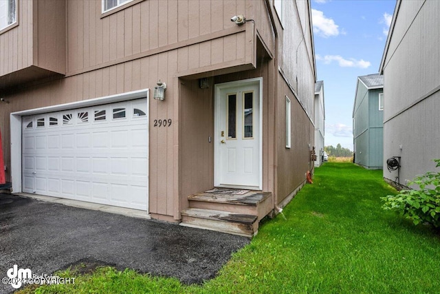 property entrance featuring a lawn and a garage