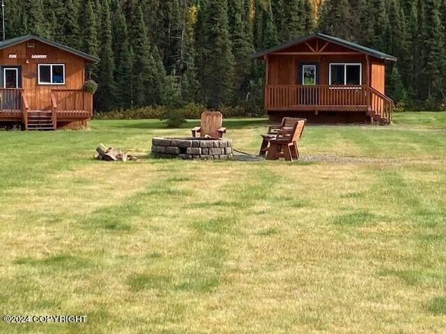 view of yard with a fire pit and an outdoor structure