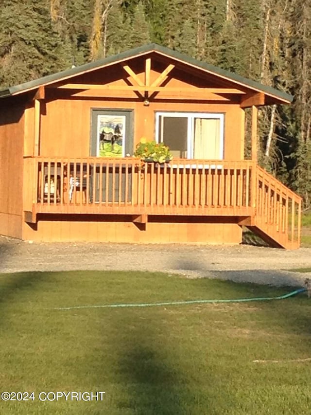 exterior space with a wooden deck and a front lawn