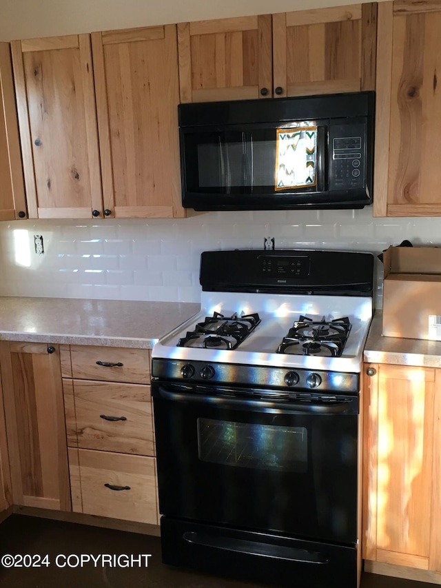 kitchen with gas range oven and backsplash