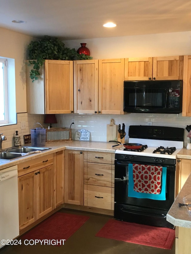 kitchen featuring black appliances, light brown cabinetry, tasteful backsplash, and sink