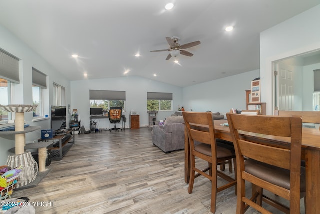 dining room with light hardwood / wood-style floors, vaulted ceiling, and ceiling fan