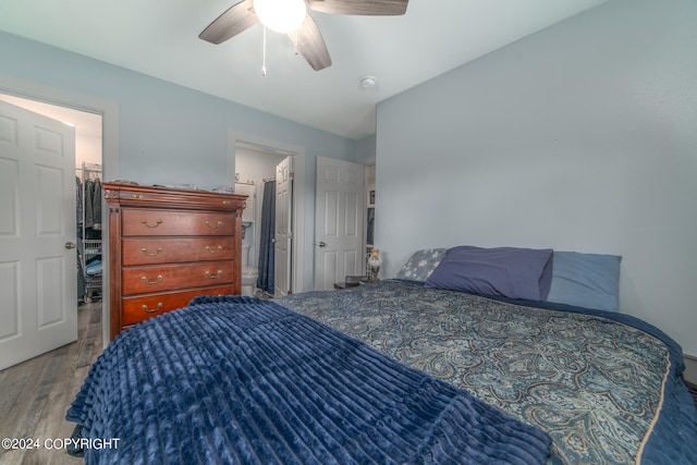 bedroom featuring light wood-type flooring, lofted ceiling, ceiling fan, and ensuite bathroom