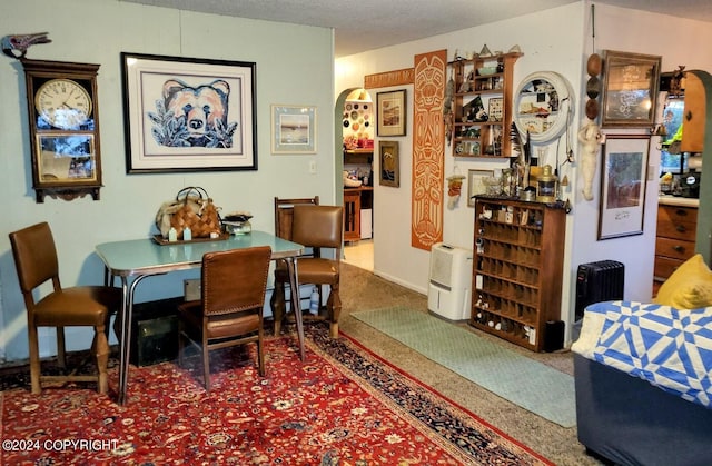 dining area with a textured ceiling and carpet flooring