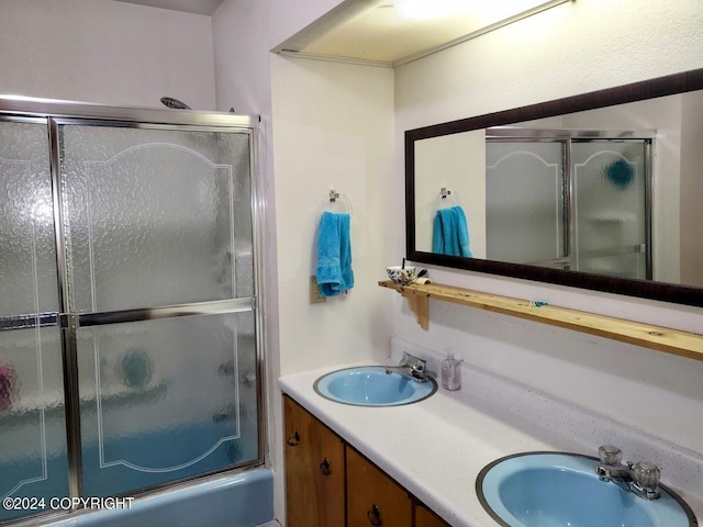 bathroom featuring shower / bath combination with glass door and vanity