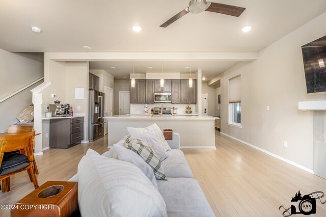 living area with ceiling fan, light wood finished floors, recessed lighting, and baseboards