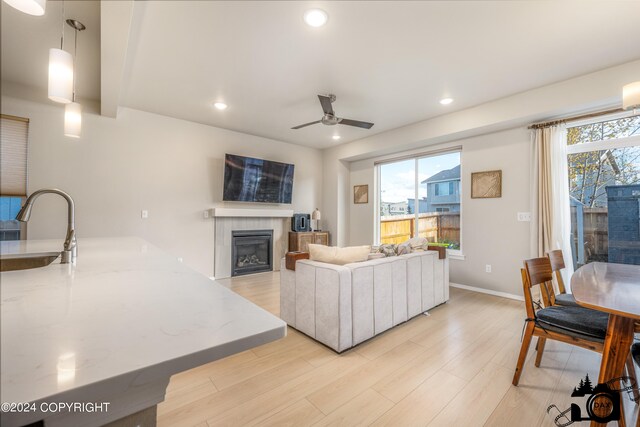 living room with plenty of natural light, recessed lighting, a fireplace, and light wood-style floors