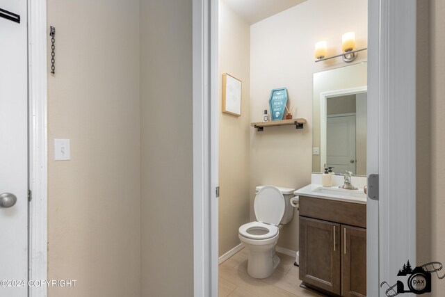 bathroom with tile patterned flooring, baseboards, vanity, and toilet