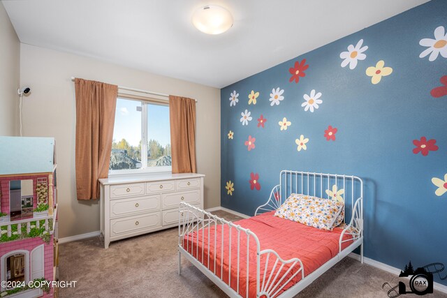 bedroom with light carpet, an accent wall, and baseboards