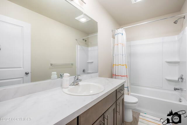 full bathroom with vanity, shower / bath combination with curtain, and toilet