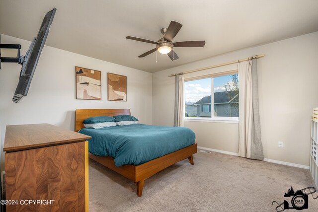 carpeted bedroom with ceiling fan and baseboards