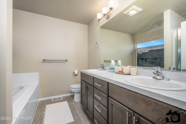 bathroom with double vanity, visible vents, toilet, and a sink