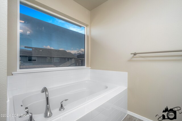 bathroom featuring baseboards and a bath