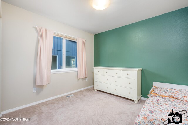 bedroom featuring baseboards, visible vents, and light colored carpet