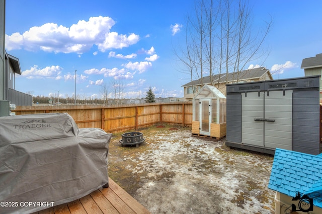 exterior space featuring a storage shed, an outdoor fire pit, an outbuilding, a grill, and fence