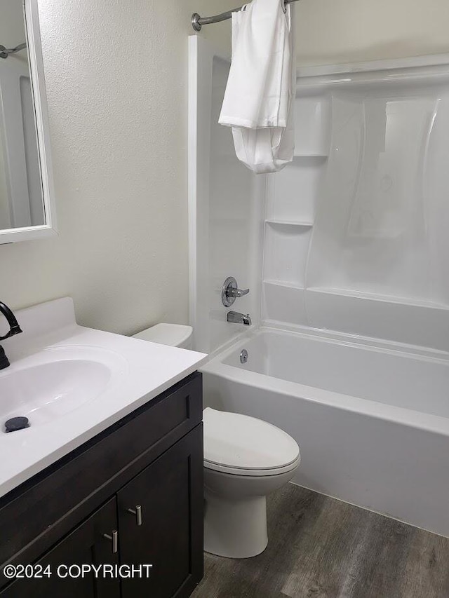 full bathroom with bathtub / shower combination, toilet, vanity, and wood-type flooring