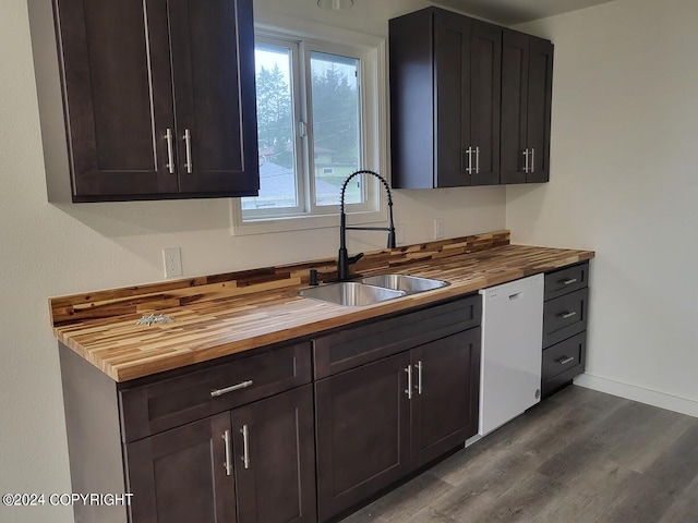 kitchen featuring dark brown cabinetry, wooden counters, sink, and white dishwasher