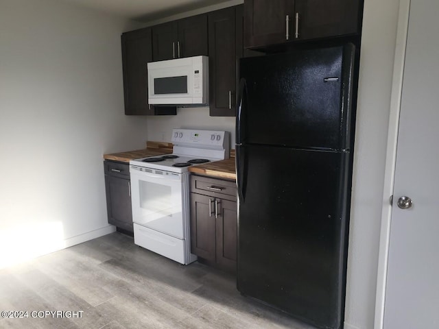 kitchen featuring wooden counters, dark brown cabinetry, light wood-type flooring, and white appliances