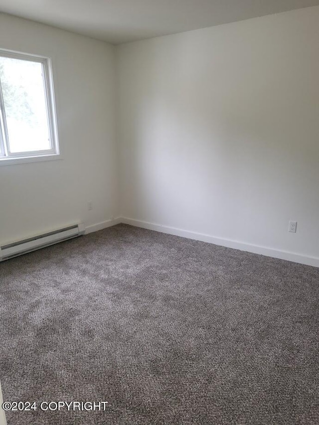 carpeted spare room featuring a baseboard radiator