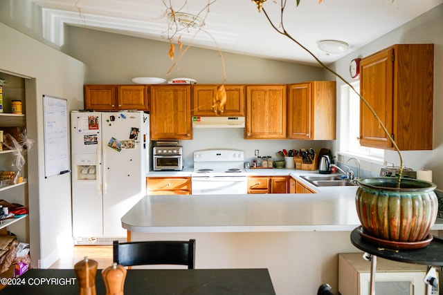 kitchen with lofted ceiling, white appliances, kitchen peninsula, and sink