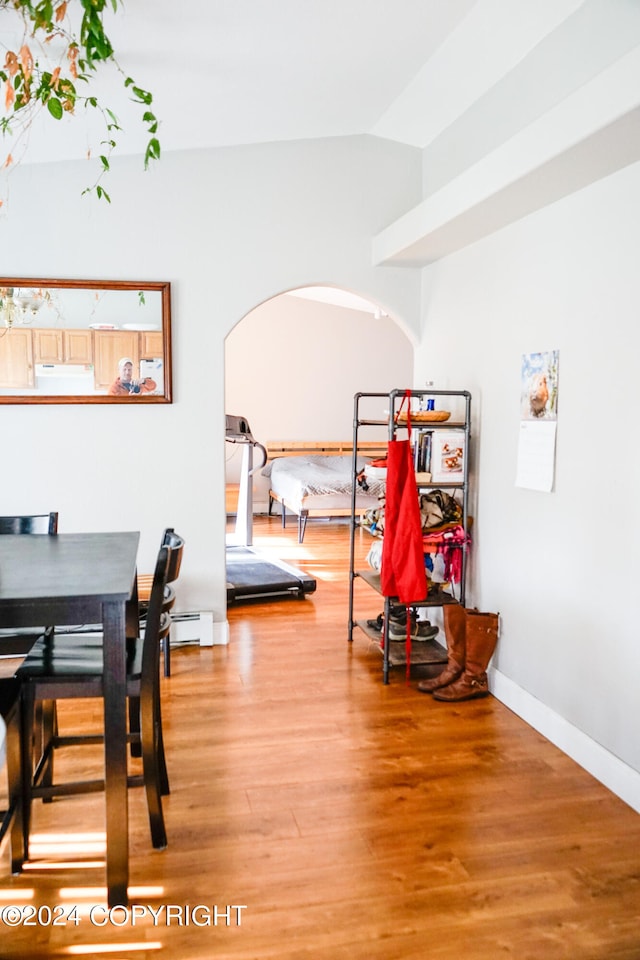 dining room with hardwood / wood-style flooring and vaulted ceiling