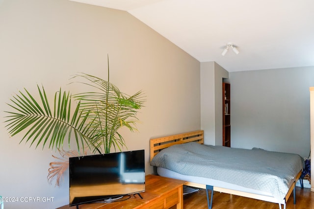 bedroom with wood-type flooring and lofted ceiling