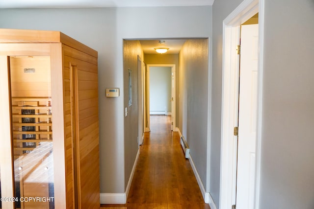 hall with baseboard heating and dark hardwood / wood-style flooring