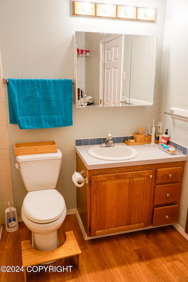 bathroom featuring vanity, toilet, and hardwood / wood-style flooring