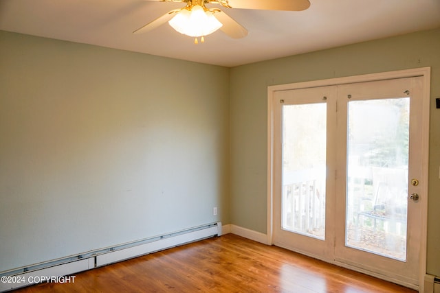 spare room featuring ceiling fan, baseboard heating, and light hardwood / wood-style floors