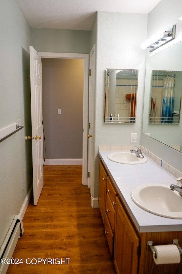 bathroom featuring vanity, a baseboard heating unit, and hardwood / wood-style flooring