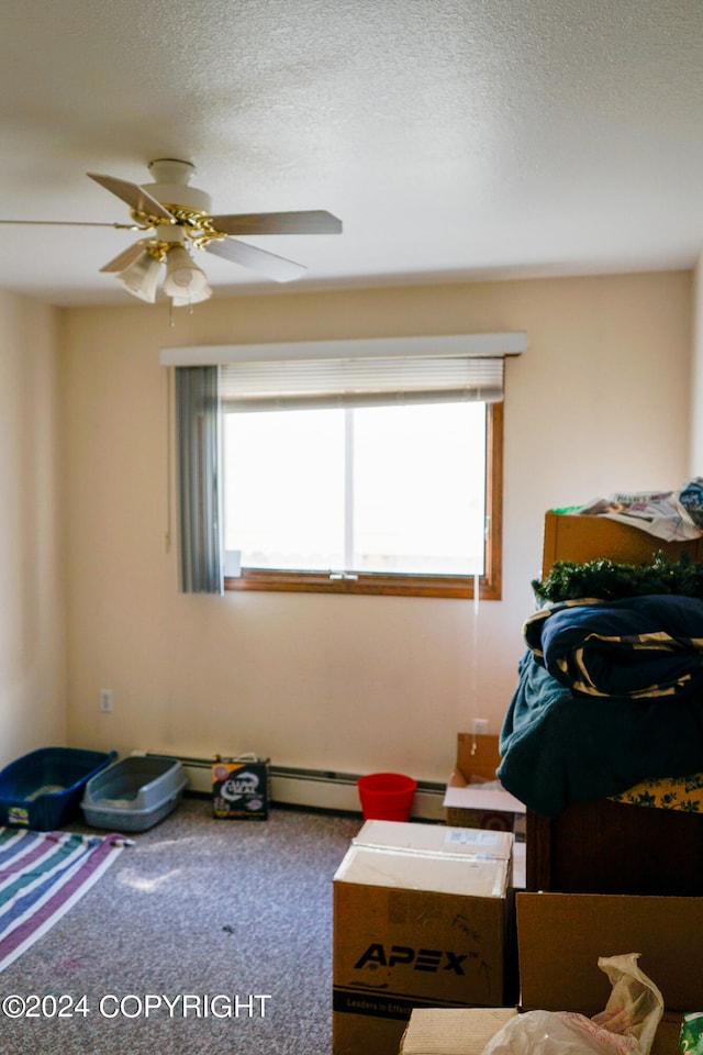 bedroom featuring multiple windows, carpet flooring, a baseboard heating unit, and ceiling fan