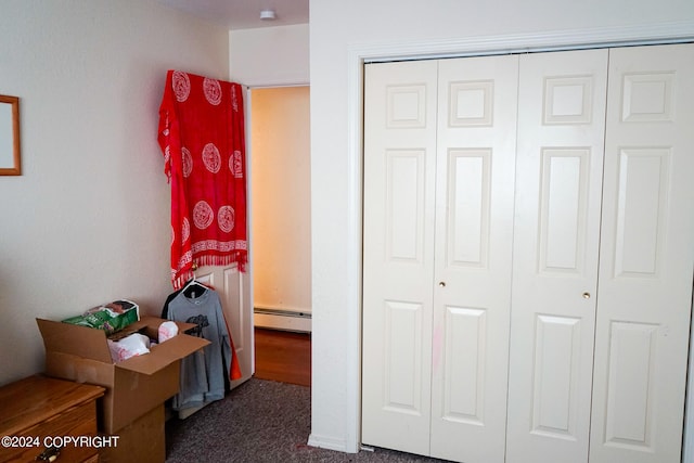 carpeted bedroom featuring a closet and a baseboard heating unit