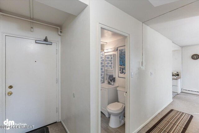 bathroom featuring baseboard heating and toilet