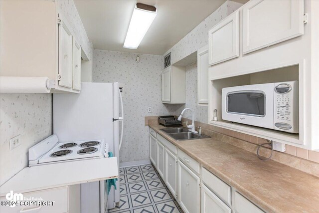 kitchen with ventilation hood, white appliances, white cabinetry, and sink