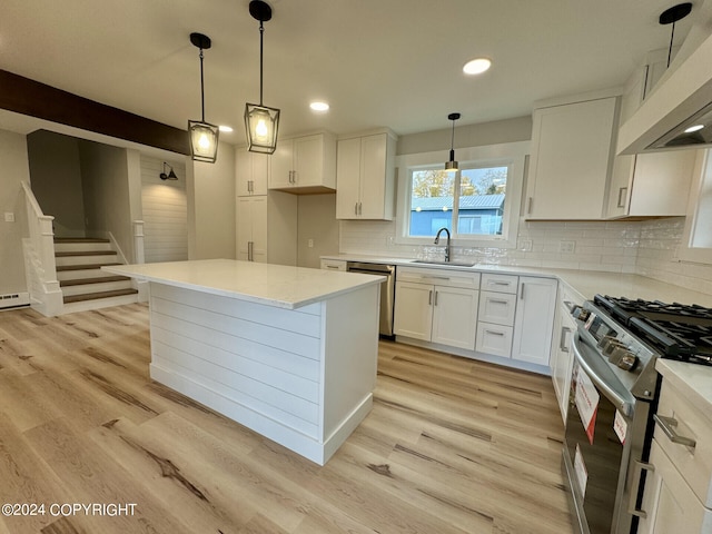 kitchen with appliances with stainless steel finishes, custom range hood, light hardwood / wood-style floors, white cabinets, and sink