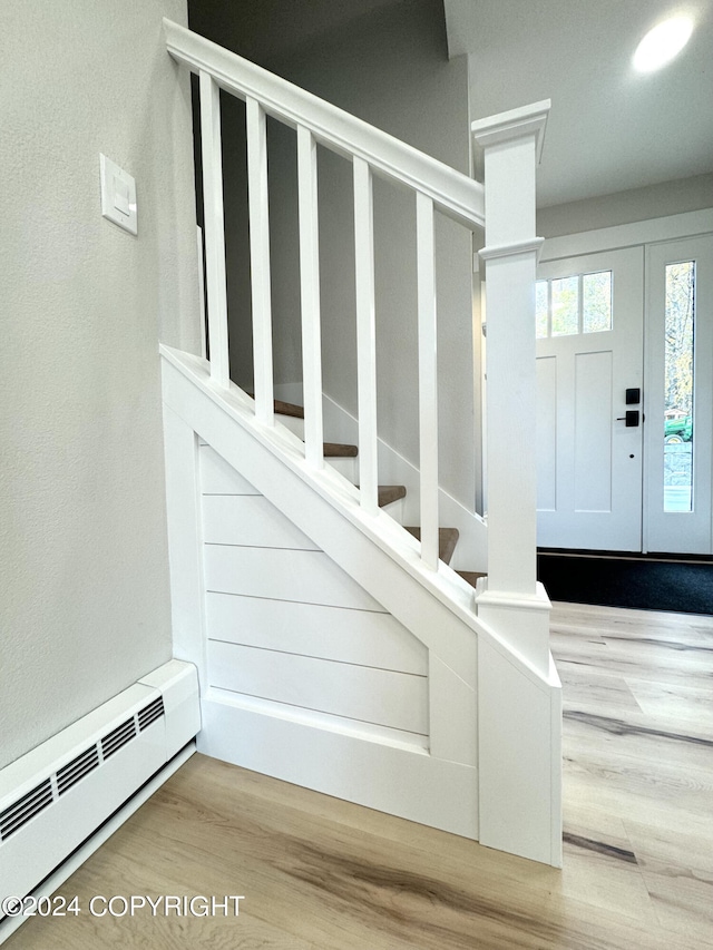 stairway featuring hardwood / wood-style flooring and baseboard heating